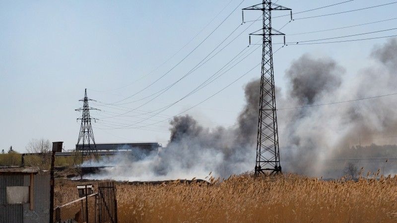 płonąca sucha trawa przy słupach i liniach energetycznych