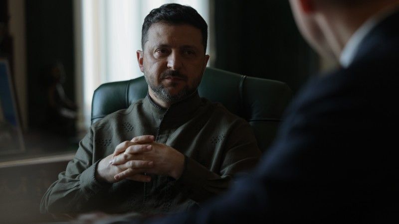 prezydent siedzi w cieniu, ręce ma złożone