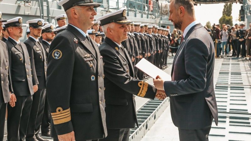 Od lewej kontradmirał Piotr Sikora i kmdr Artur Kołaczyński odbierają akty mianowania na nowe stanowiska służbowe.