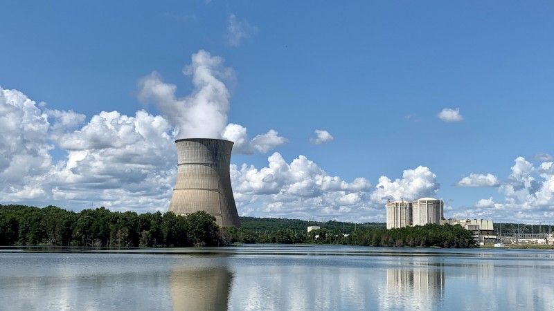 chłodnia kominowa nad wodą w otoczeniu lasu