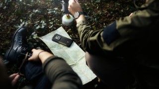Telefon na mapie obsługiwany przez osoby w mundurach