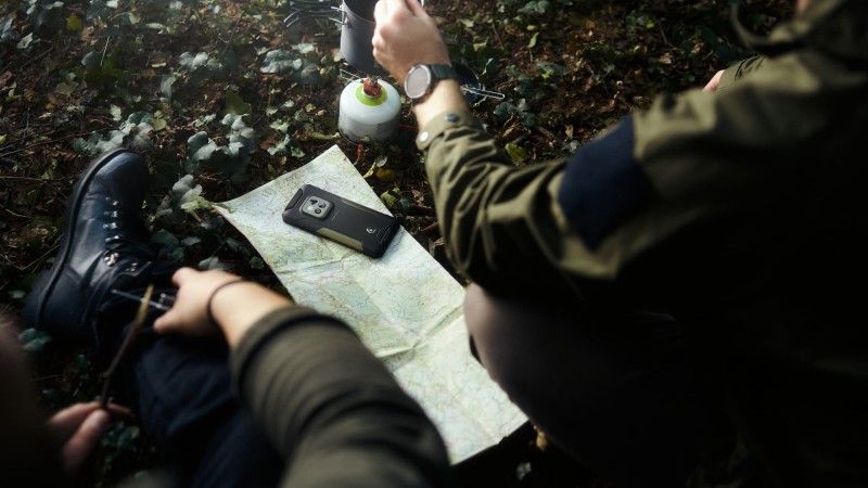 Telefon na mapie obsługiwany przez osoby w mundurach