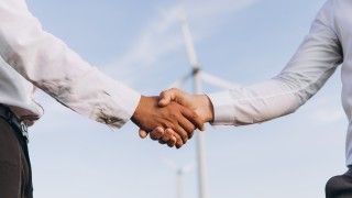 business-deal-handshake-on-wind-farm-background-2026-03-20-04-02-27-utc