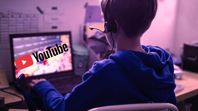 Dziecko grające w grę komputerową z logiem YouTube.