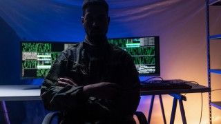man-in-camouflage-with-computer-code-background-2026-03-10-02-07-32-utc