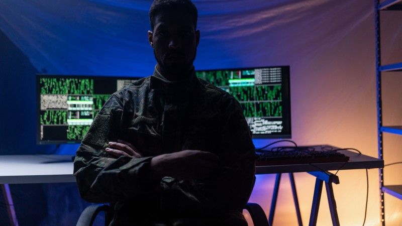 man-in-camouflage-with-computer-code-background-2026-03-10-02-07-32-utc
