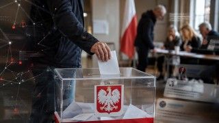 Osoba oddająca głos wrzuca kartę do urny wyborczej