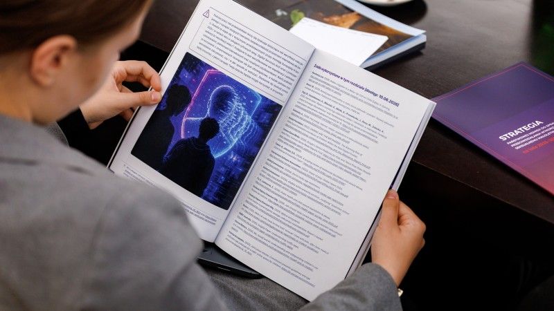 Kobieta czyta poradnik dotyczący ochrony dzieci przed wykorzystywaniem seksualnym w cyberprzestrzeni.