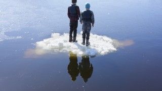 two-boys-standing-on-ice-on-lake-rear-view-2026-03-25-02-18-58-utc