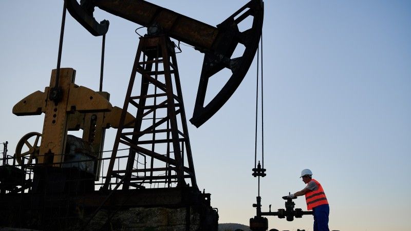 oil-well-worker-adjusting-machinery-at-dusk-2026-01-07-00-58-58-utc