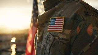 Amerykański żołnierz na tle flagi USA i wschodzącego słońca - zdjęcie ilustracyjne