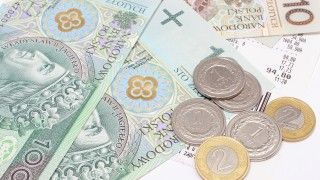 Banknoty i monety na stole - zdjęcie poglądowe