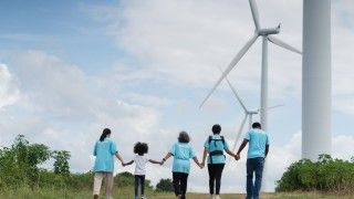 volunteers-holding-hands-near-wind-turbines-on-gra-2026-03-31-18-26-26-utc