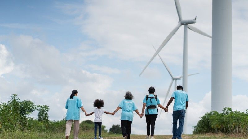 volunteers-holding-hands-near-wind-turbines-on-gra-2026-03-31-18-26-26-utc