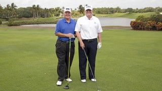 mężczyźni pozują do zdjęcia na polu golfowym, z kijami do golfa w dłoniach