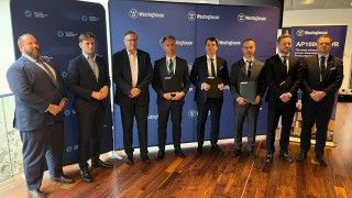 Przedstawiciele firm stoją na tle ścianek Westinghouse i PEJ