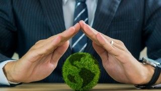 business-man-protects-green-earth-globe-on-table-2026-09-22-22-05-27-utc