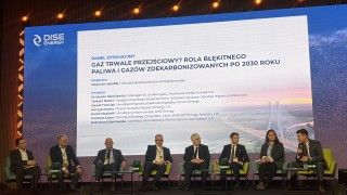 paneliści siedzą na scenie