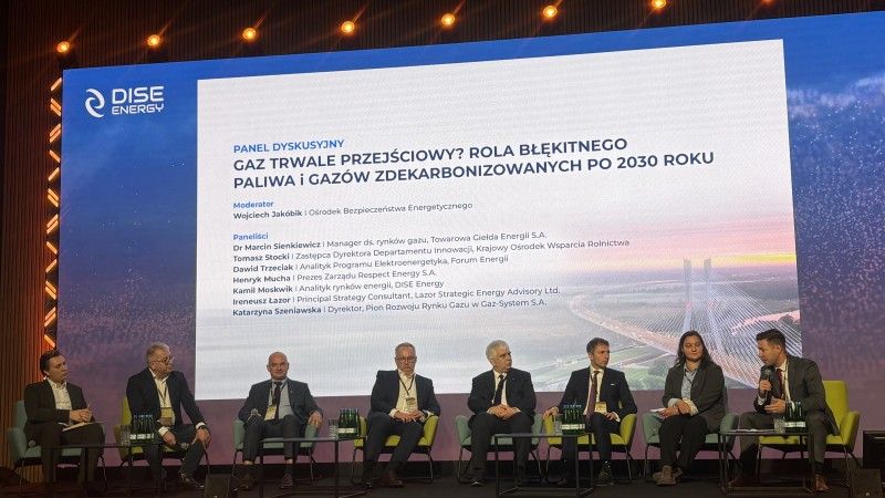 paneliści siedzą na scenie