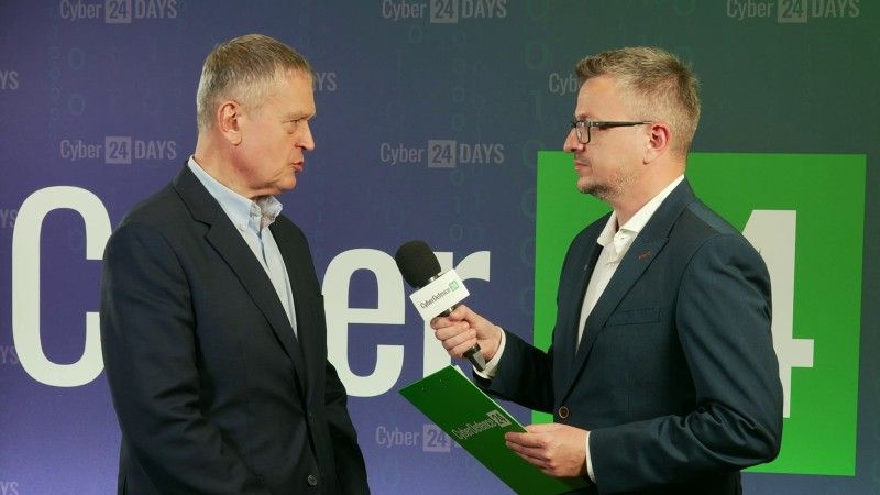 Rozmowa podczas konferencji Cyber24Days 2026. Dwóch mężczyzn w garniturach stoi na tle ścianki wydarzenia. Dziennikarz CyberDefence24 trzyma mikrofon i prowadzi wywiad dotyczący cyfrowej suwerenności Polski.
