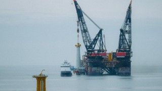 osadzanie fundamentów turbin wiatrowych na morzu w zamglony dzień