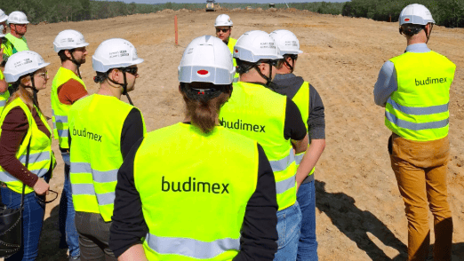 pracownicy budimex w strojach ochronnych na terenie budowy