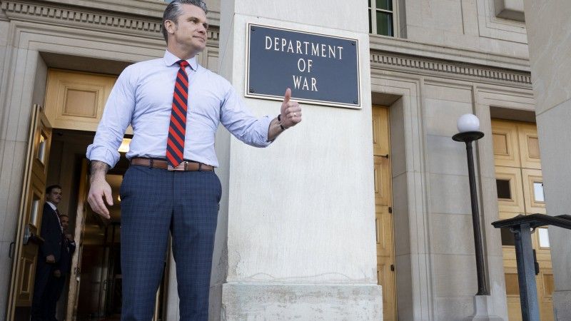 Amerykański Sekretarz Wojny Pete Hegseth pozuje do zdjęcia przed tablicą z napisem „Departament Wojny” przy wejściu do Pentagonu, 13 listopada 2025 roku.